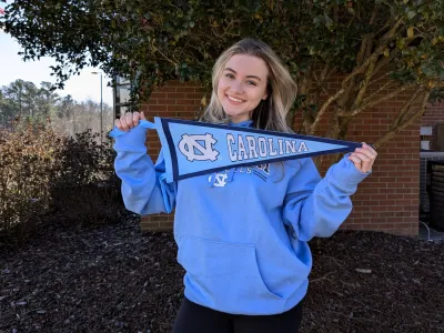 Madison Gentry holds up a pennant for UNC-CH.