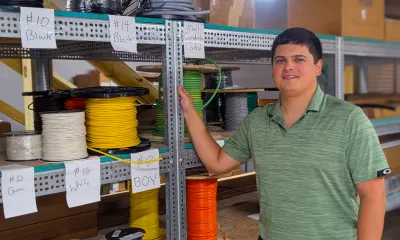 Ricky McRae stands next to spools of wire